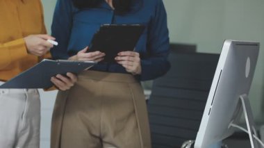 İş adamları toplantı odasında tablet üzerinde tartışıyor ve planlıyorlar.