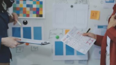 Gündelik giyinen genç bir kadın ofiste belgelerle çalışıyor..
