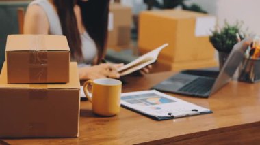 Evde çalışan genç bir kadın, çevrimiçi dağıtım, dağıtım, online iş, serbest iş, teslimat, ev ofisi için dizüstü bilgisayar kullanıyor. üzerinde çalışan kadın