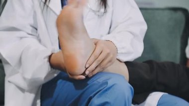 Steteskopu ve bacağı olan kadın doktor. Hasta hastanede bir hastane masasında oturuyor..