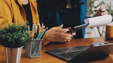 Tablet bilgisayar kullanan genç bir kadın çevrimiçi ödeme ve ödemeyi masada yapıyor..