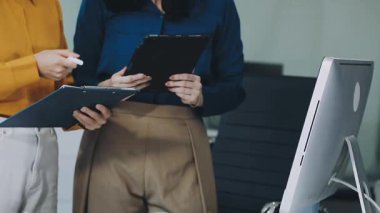 İş dünyası modern bir ofiste dijital tabletle bir planı tartışıyor.