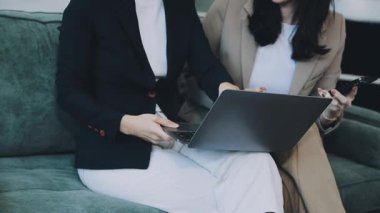 Modern ofiste dizüstü bilgisayar kullanan genç bir iş kadını.