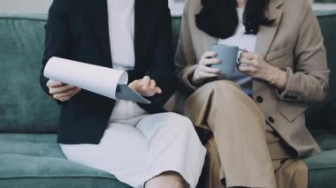 İki genç kadın kahve içiyor ve bir toplantıyı tartışıyorlar.