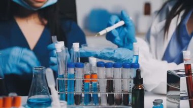 Laboratuvarda üzerinde kan örnekleri olan test tüpleri tutan kadın bilim adamı..