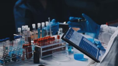 Deney tüpüyle numune tutan bilim adamı.