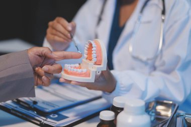Diş sağlığı kliniğinde planlı diş tedavisi hakkında dişçi ve hasta tartışması, doktorlar konuşur ve çalışır. Sağlık Bakanlığı Tıp Konferansı Konsepti