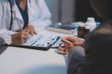 Diş sağlığı kliniğinde planlı diş tedavisi hakkında dişçi ve hasta tartışması, doktorlar konuşur ve çalışır. Sağlık Bakanlığı Tıp Konferansı Konsepti