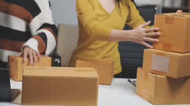 Ofiste paket paketleyen bir kadın var. çevrimiçi iş ve dağıtım kavramı