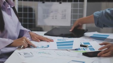 İş adamı dijital tablet kullanıyor ve masadaki grafikleri tartışıyor