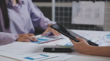 Genç işadamı akıllı telefon kullanıyor ve ofiste dizüstü bilgisayarla çalışıyor..