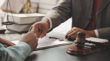 Avukat ve müvekkil ofiste yasal belgeleri tartışıyor, hukuki danışmanlık