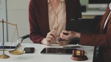 Avukat ya da yargıç tokmak ve müvekkil masada yasal belge ile