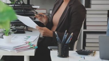 İş kadını elinde kalem tutuyor ve ofiste çalışıyor..