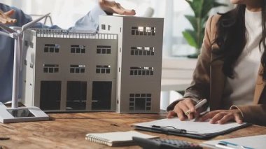 İş adamları ofiste emlakçı modelini tartışıyor..