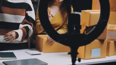 Kadın eli siyah gömlekli ve kot pantolonlu bir karton kutu taşıyor..