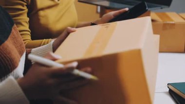 Genç Asyalı adam teslimat için akıllı telefonu kullanıyor.