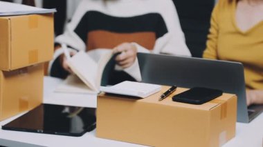 Dizüstü bilgisayarı ve kutuları olan genç bir kadın.