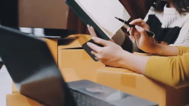 İş kadını elinde tablet, kağıda yazı yazıyor.