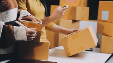 Akıllı telefon kullanan ve kutuları paketle tutan kadın.