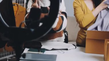 Kadın mağazadaki bir askıda elbise paketliyor..