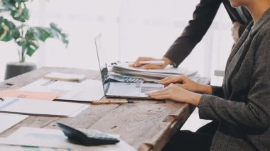 Belgeler ve dizüstü bilgisayarla çalışan iş kadınları.