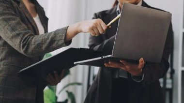 İş kadını el ele tutuşuyor ve meslektaşına boş bir ekran gösteriyor..