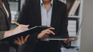 İş kadını elinde tabletle bir meslektaşıyla çalışıyor.