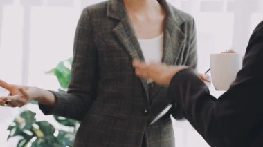 Takım elbiseli ve kravatlı genç iş kadını elinde belgelerle