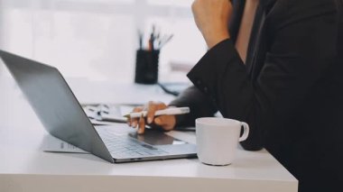 Genç iş kadını ofisteki bilgisayarını kullanıyor.