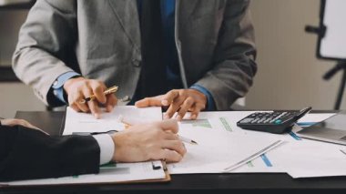 Takım elbiseli ve kravatlı genç işadamı masada oturuyor.