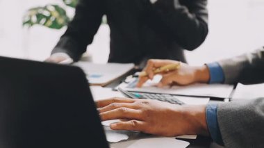 Modern ofiste finansal çizelgelerle çalışan genç bir işadamı. Dizüstü bilgisayarda çalışan iş adamlarını kapat.