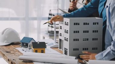 Taslak projesinde ev modeliyle birlikte çalışan mühendis mimar