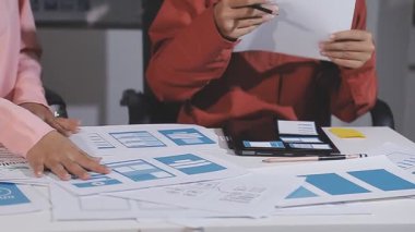 Asyalı iş kadınları ofiste iş stratejilerini tartışıyor ve planlıyorlar.