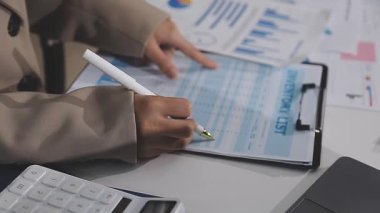 İş kadını dizüstü bilgisayar ve hesap makinesiyle çalışıyor