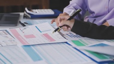 İş adamı verileri analiz ediyor ve hesap makinesiyle ofisteki grafik ve grafikleri analiz ediyor.