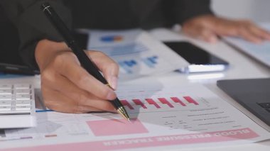 Masanın üzerinde hesap makinesi ve grafik çizelgesi kullanarak iş adamı eli