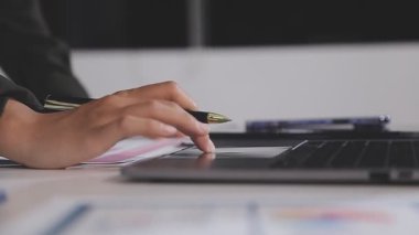 Beyaz masada dizüstü bilgisayarı kalem ve defterle tutan iş adamı..
