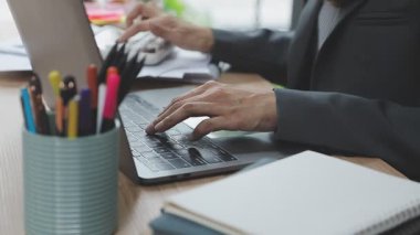 İş kadını ofiste dizüstü bilgisayarda yazarak