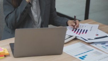 Dijital tablet kullanan ve ofisteki belgeye yazı yazan genç iş kadınlarının kapatılması.