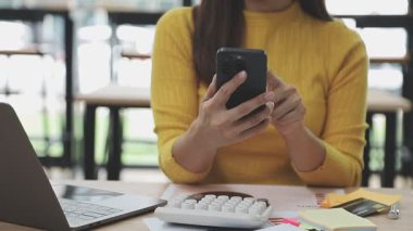 Akıllı telefon kullanan ve internetten alışveriş yapan bir iş kadını..