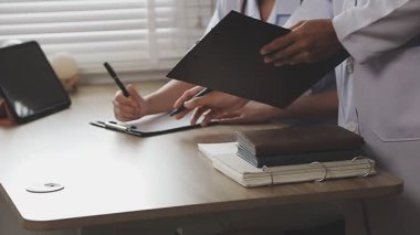 Doktor hastanın üzerine yazı yazıyor.