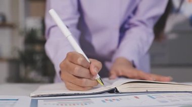 İşadamı ofiste kağıda el yazısı yazıyor.