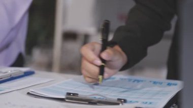 Kağıt üzerinde kalem tutan adamın ellerini kapat..