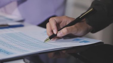 Ofiste el ele tutuşup kağıt üzerinde yazan işadamlarının kapanışı.