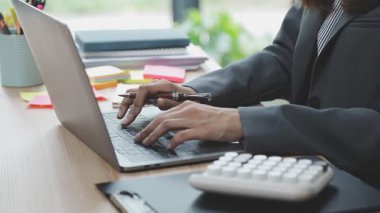 Ofisteki dizüstü bilgisayarda çalışan genç kadın.