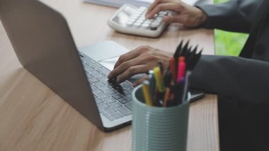 Dizüstü bilgisayar ve akıllı telefon kullanan bir iş adamı.