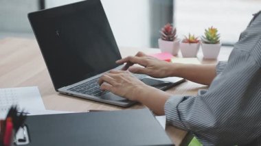 İşkadını ofiste dizüstü bilgisayarla çalışıyor.