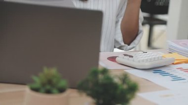 İşadamı dizüstü bilgisayarla grafiği tutuyor ve analiz ediyor