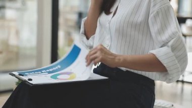 Genç Asyalı bayan yönetici ofisinde bir pano tutuyor.